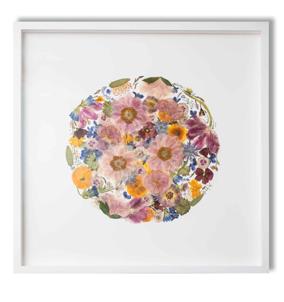 a framed print of a flower arrangement in a white frame.